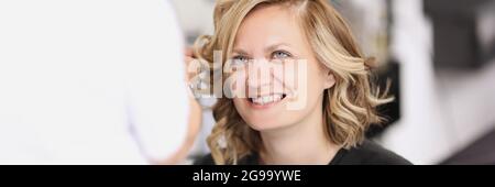 Ritratto di donna sorridente che ha i suoi capelli fatti da ricci Foto Stock