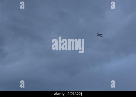 Aereo passeggeri volare tra le nuvole, luci accese Foto Stock