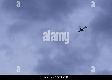 Aereo passeggeri volare tra le nuvole, luci accese Foto Stock