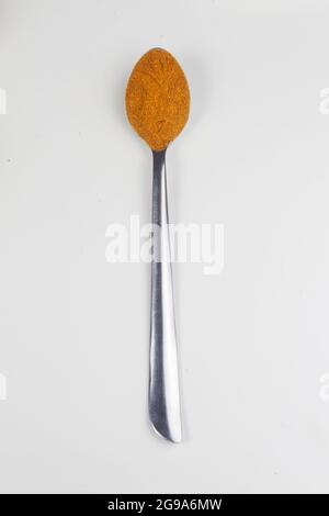 Indiano Spice colorato anche conosciuto come Coriander polvere, Dhaniya polvere isolato su sfondo bianco in cucchiaio. Foto Stock