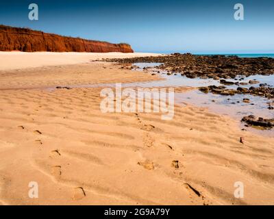 Orme nella sabbia e le scogliere rosse di pindan a Walmadan (James Price Point), Dampier Peninsula, Kimberley, Australia Occidentale Foto Stock