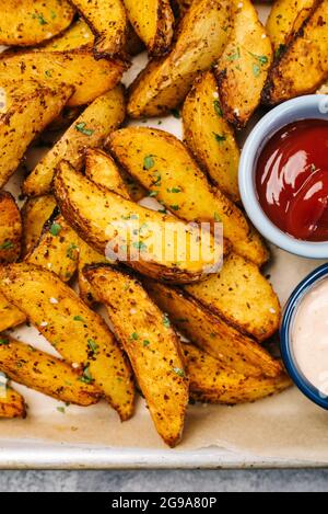 Foto dall'alto di spicchi di patate speziate nella friggitrice Foto Stock