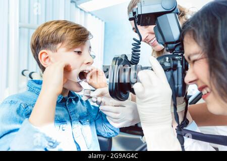 Dentista femminile che prende raggi di denti del ragazzo paziente Foto Stock