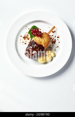 Cotoletta di Kiev con purè di patate e un rametto di ribes rosso su un piatto leggero, spazio copia sfondo bianco, servizio originale di cotoletta di Kiev, vista dall'alto Foto Stock