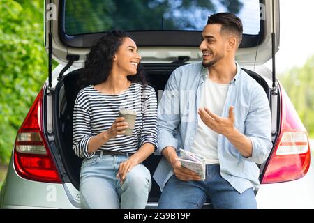 Una coppia multirazziale spensierata che ha fatto una pausa durante il viaggio in auto Foto Stock