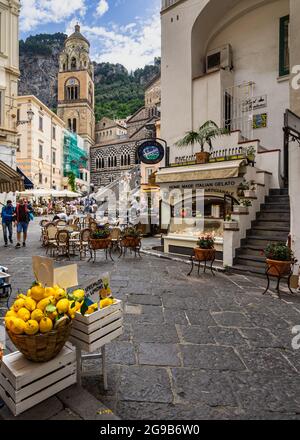 Amalfi, Italia, 2021 giugno – Vista sull'incantevole piazza principale di Amalfi con negozi di frutta fresca e la cattedrale sullo sfondo Foto Stock