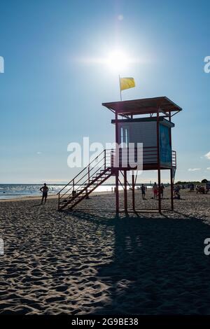 Pärnu, Estonia - 11 luglio 2021: La torre del bagnino G4S con bandiera gialla indica che il nuoto è pericoloso per i nuotatori poveri. Foto Stock