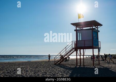 Pärnu, Estonia - 11 luglio 2021: La torre del bagnino G4S con bandiera gialla indica che il nuoto è pericoloso per i nuotatori poveri. Foto Stock