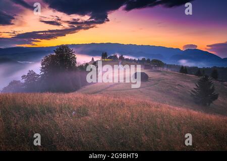 Fantastico paesaggio di campagna autunnale con nebbie pendii e valli dopo la pioggia al tramonto, Transilvania, Romania, Europa Foto Stock