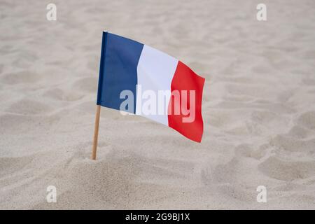 Bandiera della Francia su sfondo sabbioso. Bandiera francese sventolante sulla spiaggia estiva Foto Stock