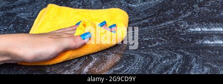 Pulizia del piano di lavoro. Cura per i countertops nella cucina o nel bagno. Pulizia di superfici in pietra, marmo o pietra artificiale. Foto Stock