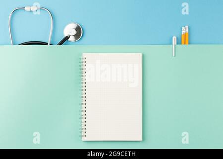 Stetoscopio con blocco note sulla scrivania dell'infermiere. Foto Stock