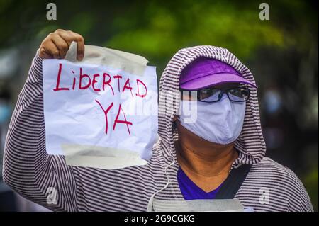 San Salvador, El Salvador. 25 luglio 2021. Una donna tiene un segno che dice Freedom ora durante la dimostrazione. Cinque ex funzionari del primo governo di sinistra FMLN (Frente Farabundo Martí para la Liberación Nacional) sono stati accusati di accuse di corruzione dall'ufficio del procuratore generale. I sostenitori della FMLN protestano ha detto che la decisione di chiamare questa prigione politica, in quanto l'attuale procuratore generale è stato imposto dal partito al governo dopo aver cacciato il procuratore costituzionale e cinque giudici superiori. Credit: SOPA Images Limited/Alamy Live News Foto Stock