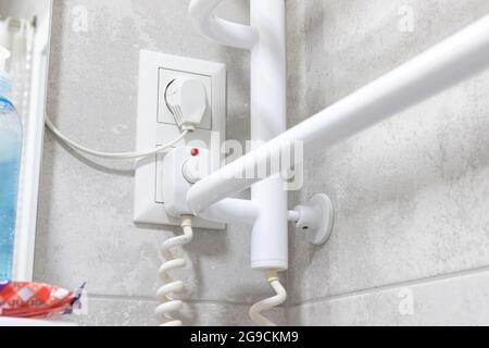 Scaldato ringhiera e radiatore attrezzature in bagno moderno in appartamento, pankcground Foto Stock