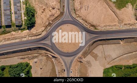 Vista aerea dall'alto di una rotatoria del traffico. Vista dall'alto del traffico circolare di auto e camion sulla circonvallazione. Risolvere il problema di Foto Stock