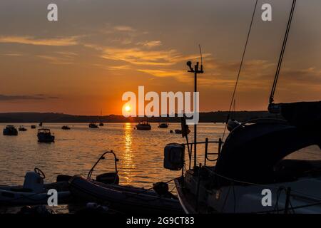 Courtmacsherry, West Cork, Irlanda. 25 luglio 2021. Il sole tramonta su Courtmacsherry Marina dopo una giornata di sole glorioso e temperature molto calde. Met Éireann ha previsto pioggia e temporali da domani in poi. Credit: AG News/Alamy Live News Foto Stock