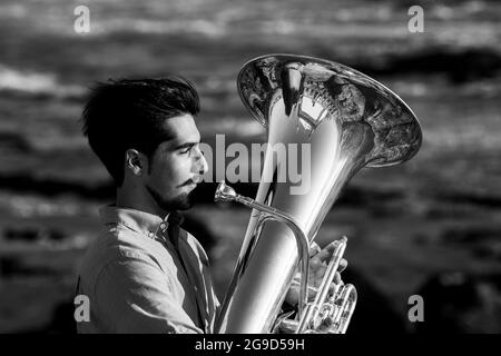 Ritratto di musicista con tromba in riva al mare. Foto in bianco e nero. Foto Stock