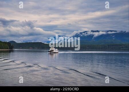 BC, Canada - 24 giugno 2019: Il traghetto che naviga attraverso il lago, trasportando passeggeri e auto. Bellissimo scenario su entrambi i lati del fiordo, con l Foto Stock