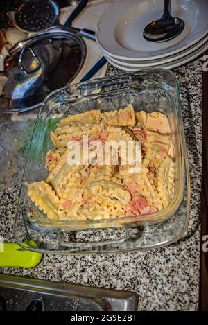 Piatto di pasta italiana fatto in casa, tagliatelle ripieni di spinaci e ricotta con salsa alla panna, cipolle, aglio, prosciutto, spezie aromatiche e parmigiano Foto Stock