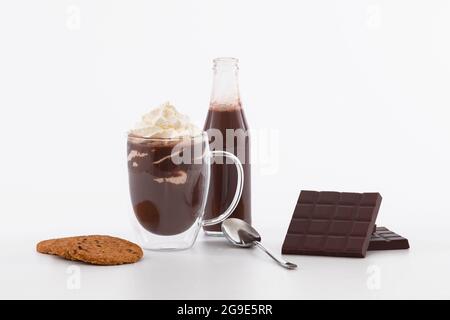 Bicchiere di frullato di cioccolato dolce con panna montata e barrette di cioccolato su sfondo bianco Foto Stock