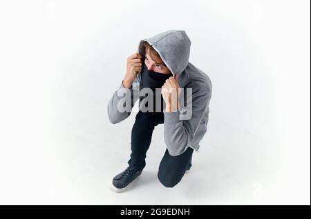 uomo mascherato agganciato nascondendo il suo furto di faccia Foto Stock