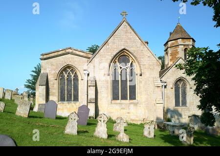 La chiesa di St Leonard, costruita dai conquistatori normanni nell'XI secolo d.C., sotto il castello e sopra il villaggio inglese di Rockingham. Foto Stock