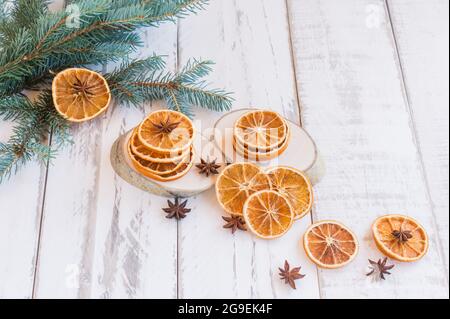 sfondo festivo di natale con rami di abete, arance secche e stelle di anice su tavola rustica in legno. Foto Stock