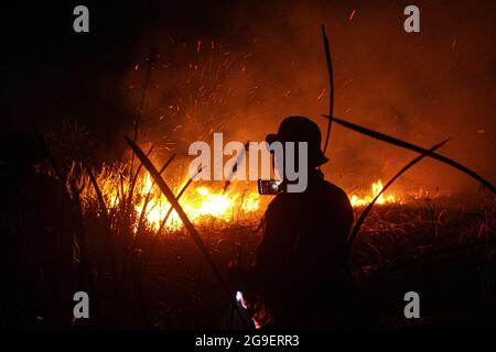 Ogan Ilir, Indonesia. 25 luglio 2021. Ufficiali di Manggala Agni Daops Banyuasin estinguono gli incendi dei peatland nel villaggio di Istanbul 1, nel distretto di Pemulutan, nella reggenza di Ogan Ilir, Sumatra meridionale. Questo fuoco di terra si è verificato a 10.00 WIB con un'area di ????circa 4 ettari di torba bruciata (foto da Humaidy Kenedy/Pacific Press/Sipa USA) Credit: Sipa USA/Alamy Live News Foto Stock