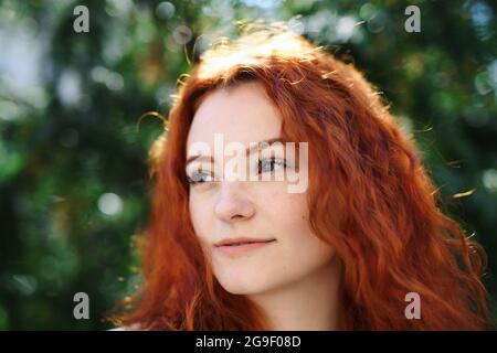 Primo piano ritratto di giovane donna all'aperto in città, headshot. Foto Stock