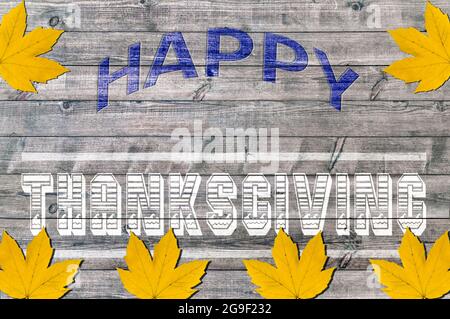 Felice Ringraziamento scritto su tavola di legno con foglia d'autunno Foto Stock