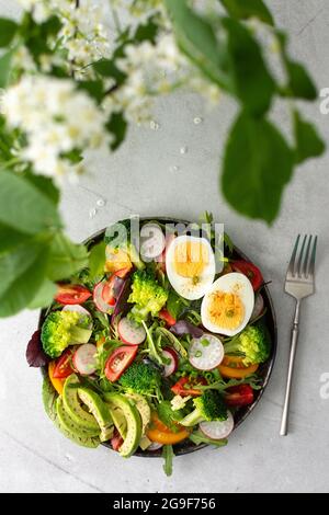 Deliziosa colazione leggera, insalata con pomodori e ravanelli, avocado e uova sode, vista dall'alto Foto Stock