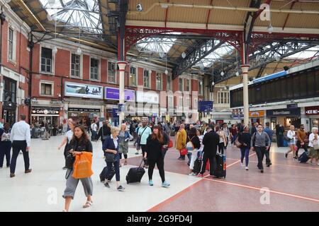 LONDRA, Regno Unito - 15 LUGLIO 2019: I passeggeri visitano la stazione Victoria di Londra. La stazione di Victoria serve oltre 73 milioni di viaggiatori ogni anno. Foto Stock