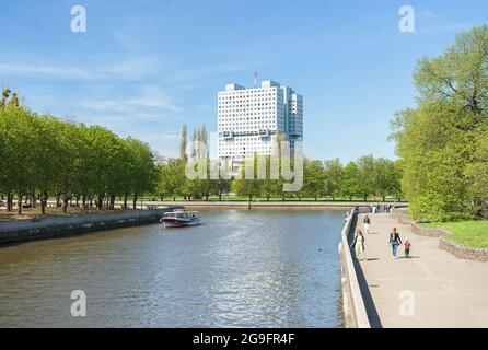 Kaliningrad, Russia - 10 maggio 2021: Vista dell'edificio abbandonato della Casa dei Soviet e del fiume Pregolya con le persone che camminano sul suo argine Foto Stock