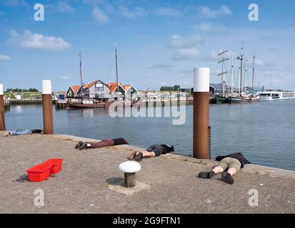 vecchie navi a vela in legno nel porto di oudeschild sull'isola olandese di texel, mentre la gente pesca per granchio e l'uomo scatta foto Foto Stock