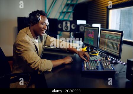 Male dj che lavora su un nuovo successo, studio di registrazione Foto Stock