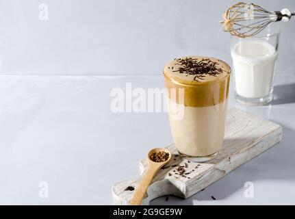 Bevanda a base di caffè Dalgon in alta pallina su supporto in legno con un cucchiaio in legno su sfondo grigio con testo in copia Foto Stock