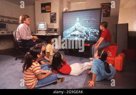 Texas USA, marzo 1998: Gli studenti della scuola media guardano un feed dal vivo da un mestiere esplorativo sottomarino durante una lezione di video scienza. ©Bob Daemmrich Foto Stock