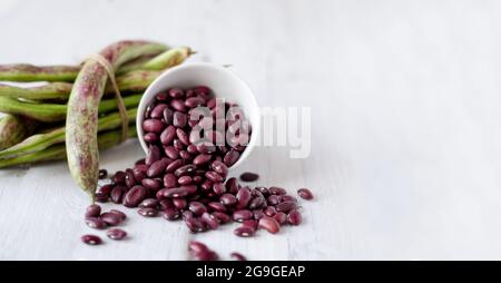 I fagioli sono rossi su sfondo bianco. Il concetto di cibo vegetariano sano con spazio di riproduzione Foto Stock