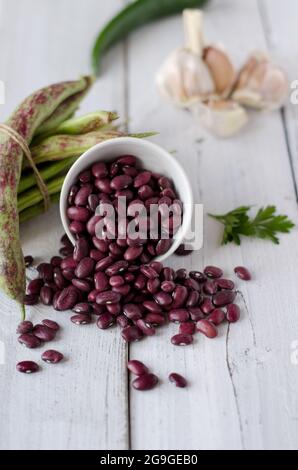 Fagioli rossi primo piano su sfondo bianco di legno. Il concetto di cibo vegetariano. Foto Stock