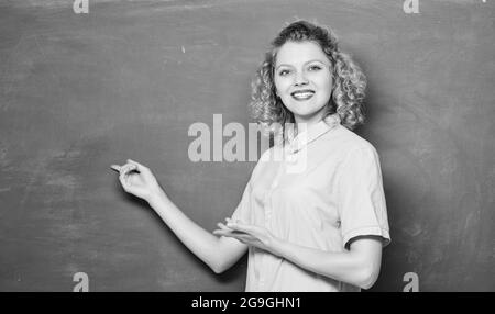 Un buon insegnante è il maestro della semplificazione. Insegnante di donna di fronte alla lavagna. L'insegnante spiega l'argomento duro. Appassionato di conoscenza. Insegnare potrebbe Foto Stock