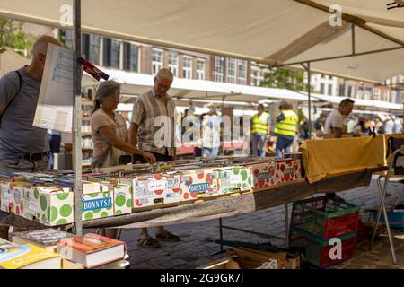 ZUTPHEN, PAESI BASSI - 25 luglio 2021: Stand in una fiera del libro nel centro della città storica visto da dietro durante la pandemia COVID-19 in una giornata di sole. Foto Stock