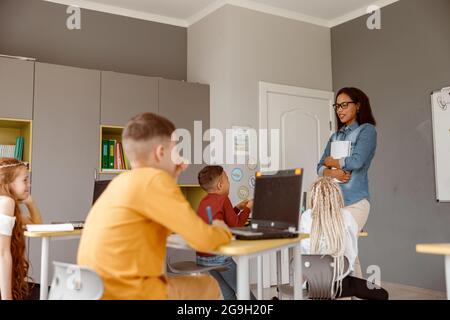 Alunni che ascoltano attentamente l'insegnante nella lezione Foto Stock