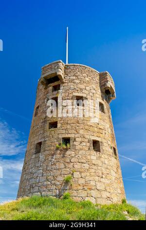 Le Hocq Tower sulla riva sud di Jersey, Isole del canale, Gran Bretagna, in una giornata estiva soleggiata, contro il cielo blu. Foto Stock