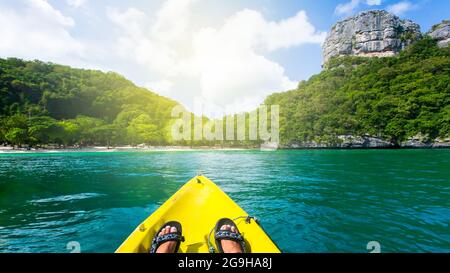 Kayak sull'isola tropicale in estate soleggiato. Vista dal kayak giallo sul mare blu con sfondo verde dell'isola. MU Koh Ang Thong, Thailandia. Foto Stock