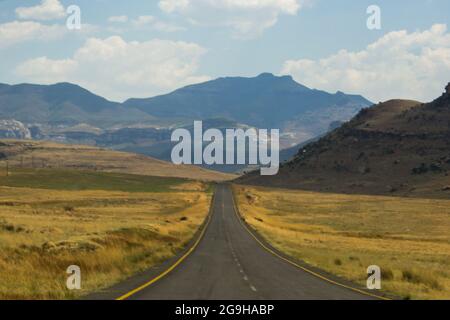 Un'autostrada deserta, in direzione dei Monti Drakensberg in Sud Africa Foto Stock