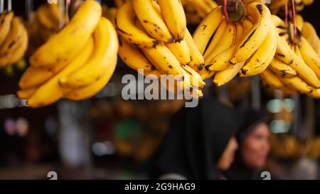 Primo piano di banane mature frutta mostra in un negozio di alimentari locale. Un mazzo di banane gialle mature con macchie scure in una drogheria locale. Foto Stock