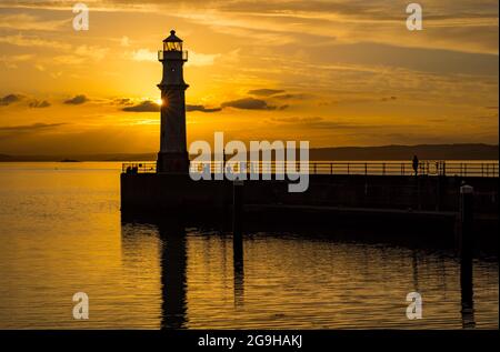 Il faro del porto di Newhaven si trova in un colorato cielo arancione con un'esplosione di sole al tramonto, Edimburgo, Scozia, Regno Unito Foto Stock