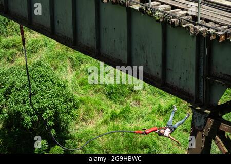 Amaga, Antioquia, Colombia - Luglio 18 2021: L'uomo ispanico Bungee salta con l'imbracatura nel bosco Foto Stock