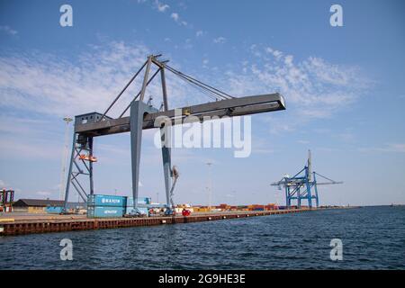 Terminal porta container con enorme gru vicino all'acqua. Cielo blu con sfondo nuvole sparse. Spazio di copia. Copenaghen, Danimarca - 25 luglio 2021. Foto Stock