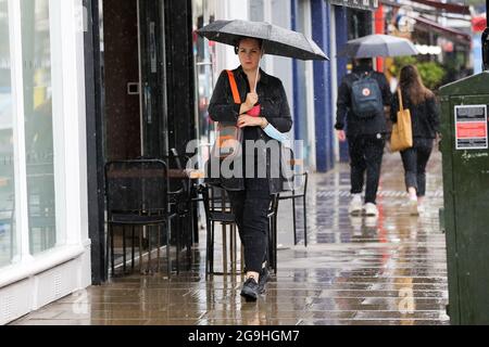 Una donna si protegge dalla pioggia sotto un ombrello a Londra, dopo la recente ondata di caldo. (Foto di Dinendra Haria / SOPA Images/Sipa USA) Foto Stock